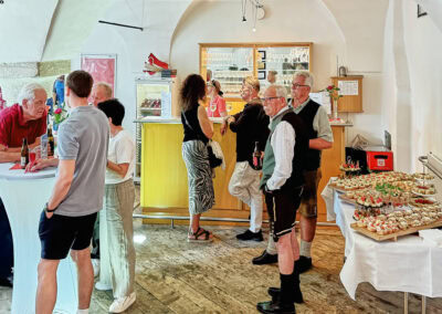 Gesellschaft bei Veranstaltung im Museum mit Snacks und Gesprächen.